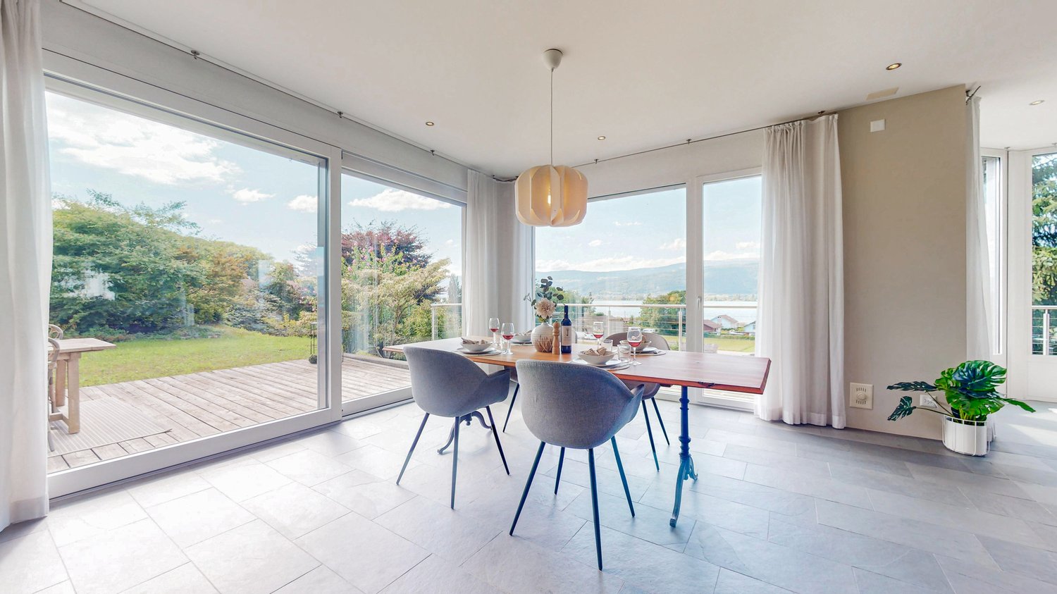 dining room with a wooden table, chairs, large glass doors, glass floor, wooden floor, plant, large windows, balcony