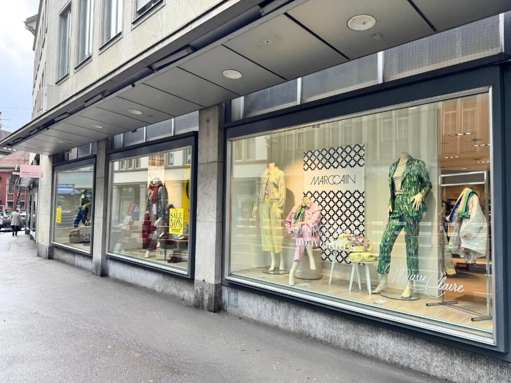 A building with a shop on the ground floor, glass windows, and a signboard with the text 'MARCAIN'.