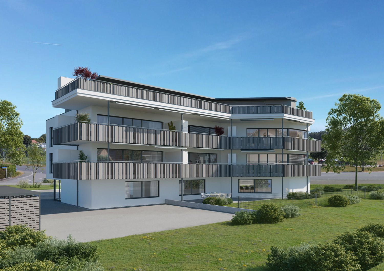 3-story modern apartment building with white exterior walls, black balcony railings, and large windows. The building has a flat roof and is surrounded by a grassy lawn with trees.