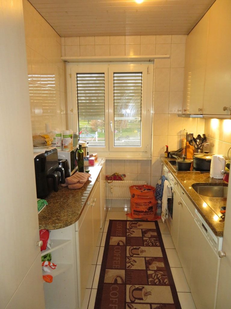 kitchen, white cabinets, tiled walls, wooden countertop, sink, white tiled floor, coffee machine, microwave, refrigerator, dish washer