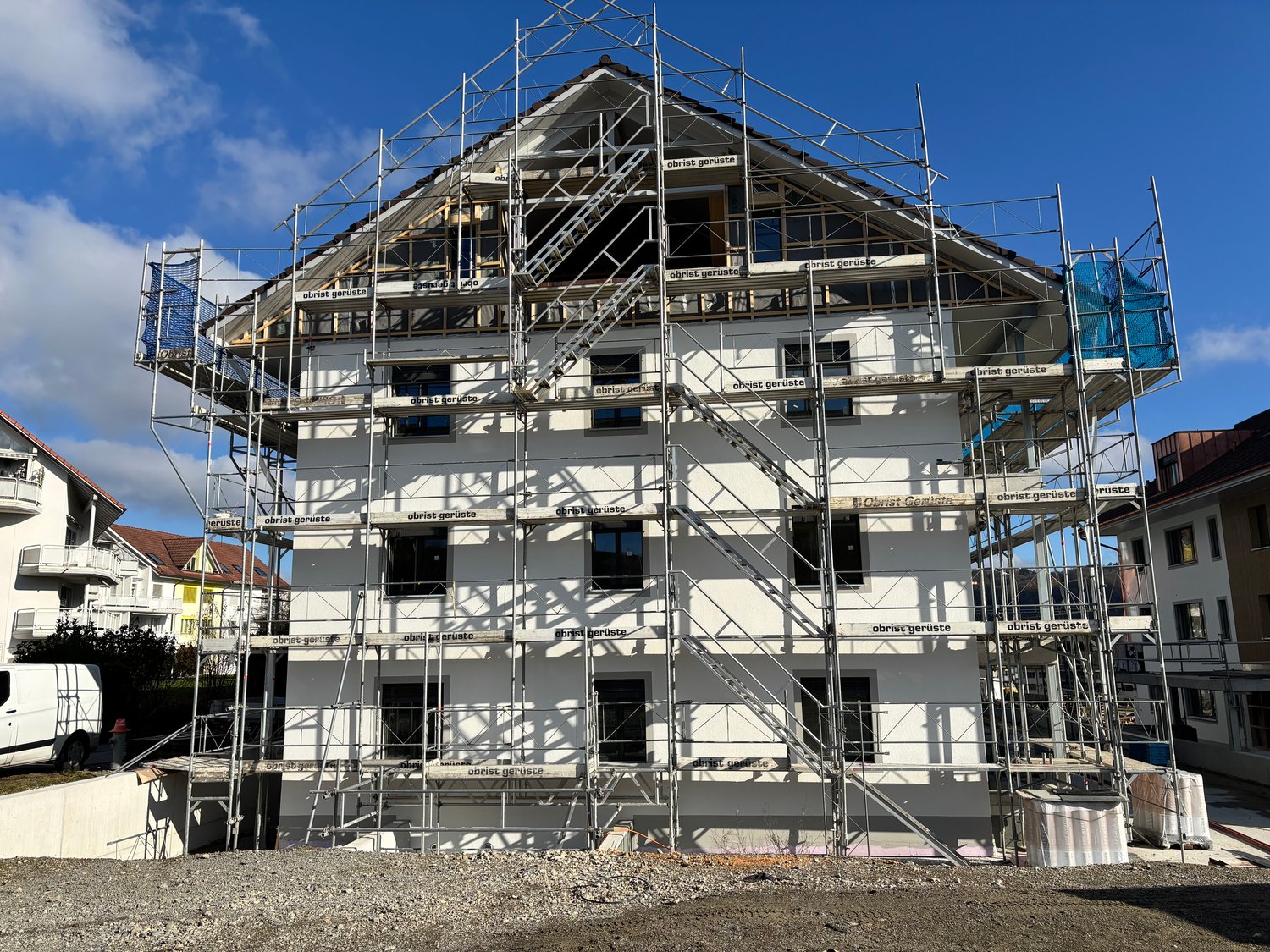 3 story house, white exterior, scaffolding, windows, roof in construction