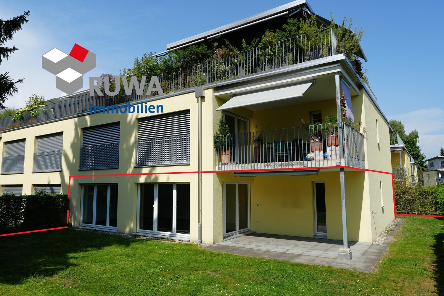 2 story yellow house, glass doors, garage, plants on balcony, green grass