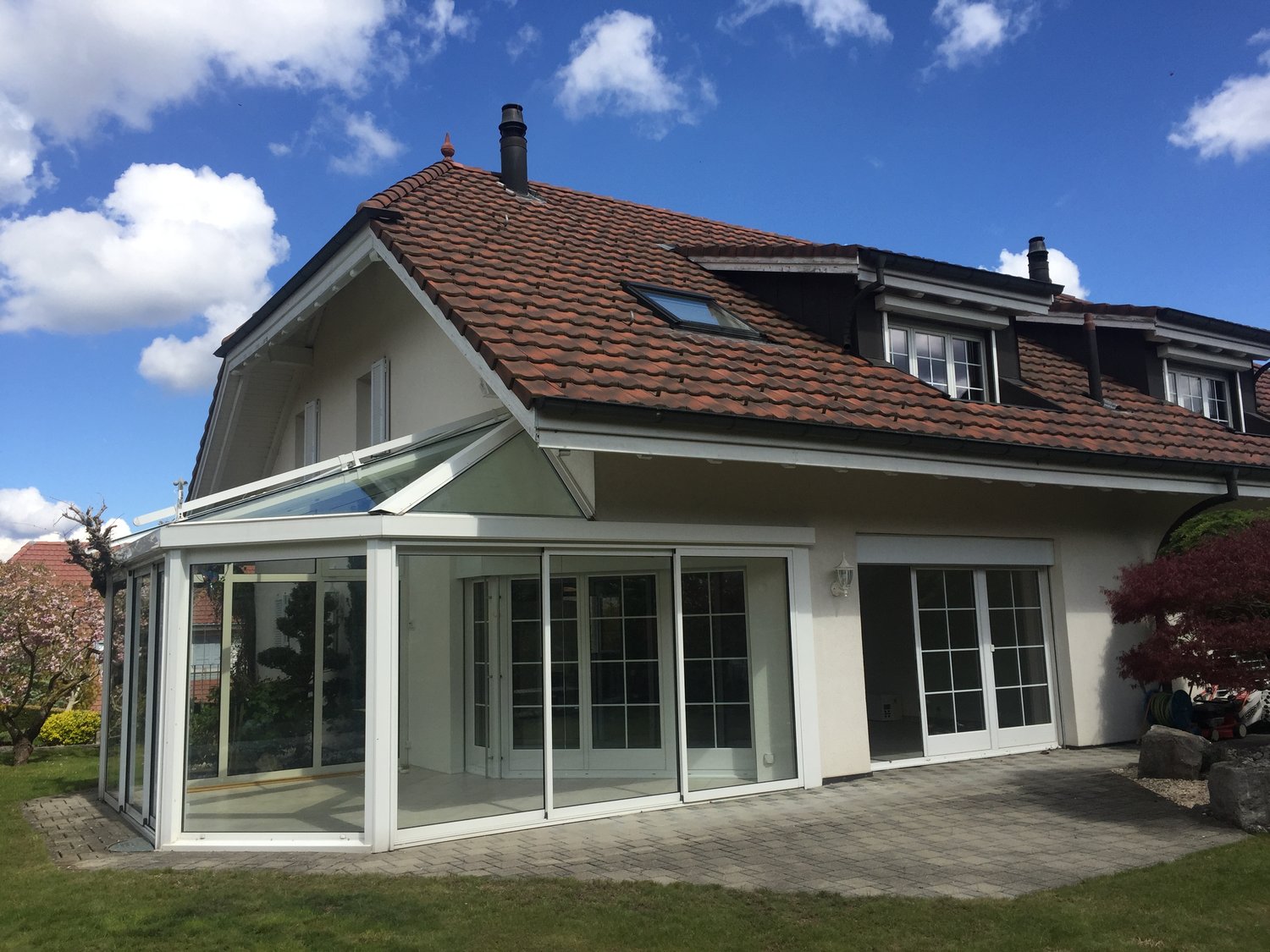 Red roof, white facade, glass terrace, sliding doors, skylight, garden, chimney