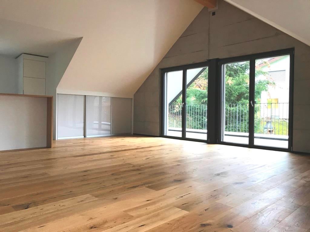 empty room, hardwood floor, sliding doors leading to balcony, white walls, storage cabinets