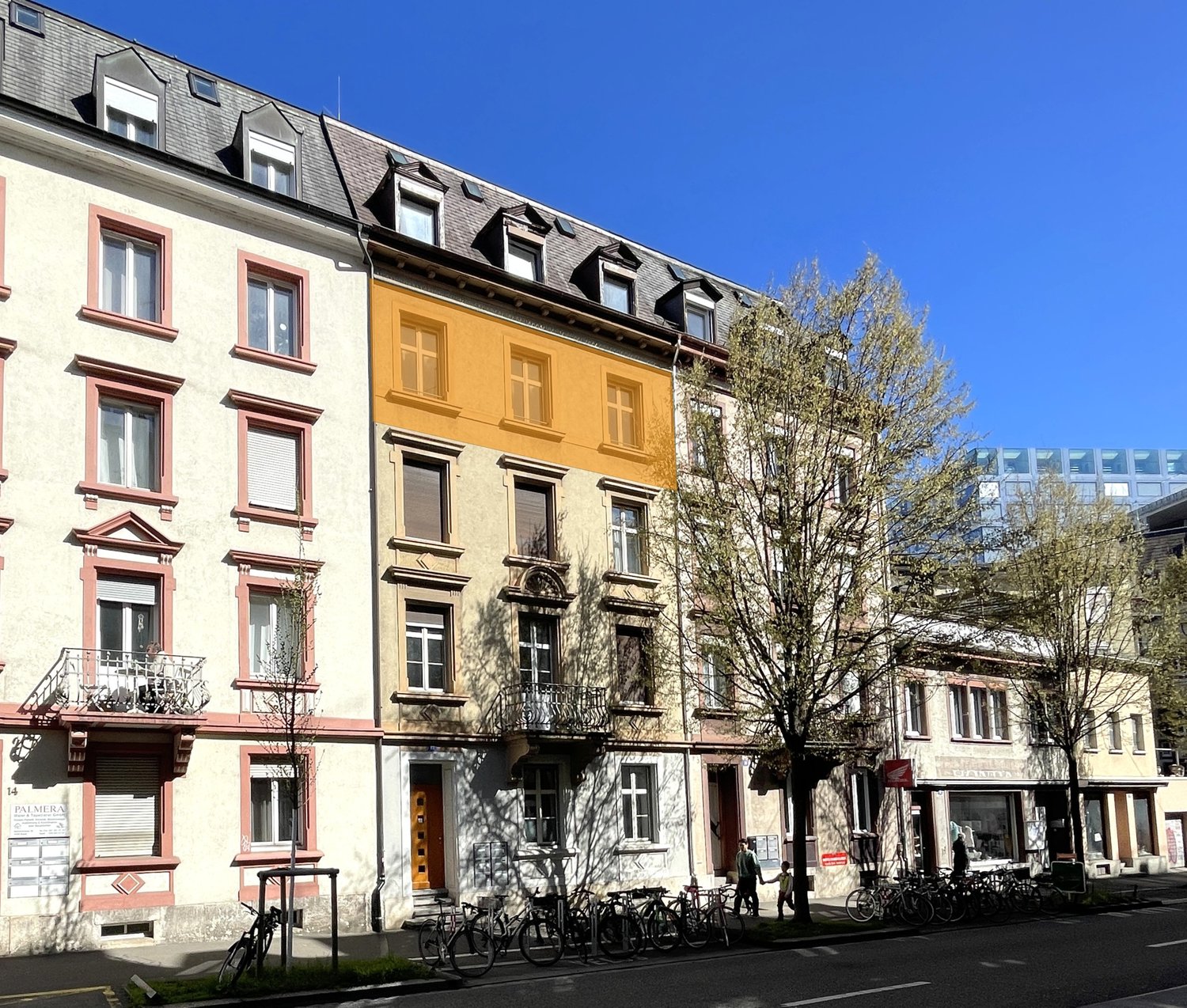 5 story building, multiple balconies, bicycles parked in front
