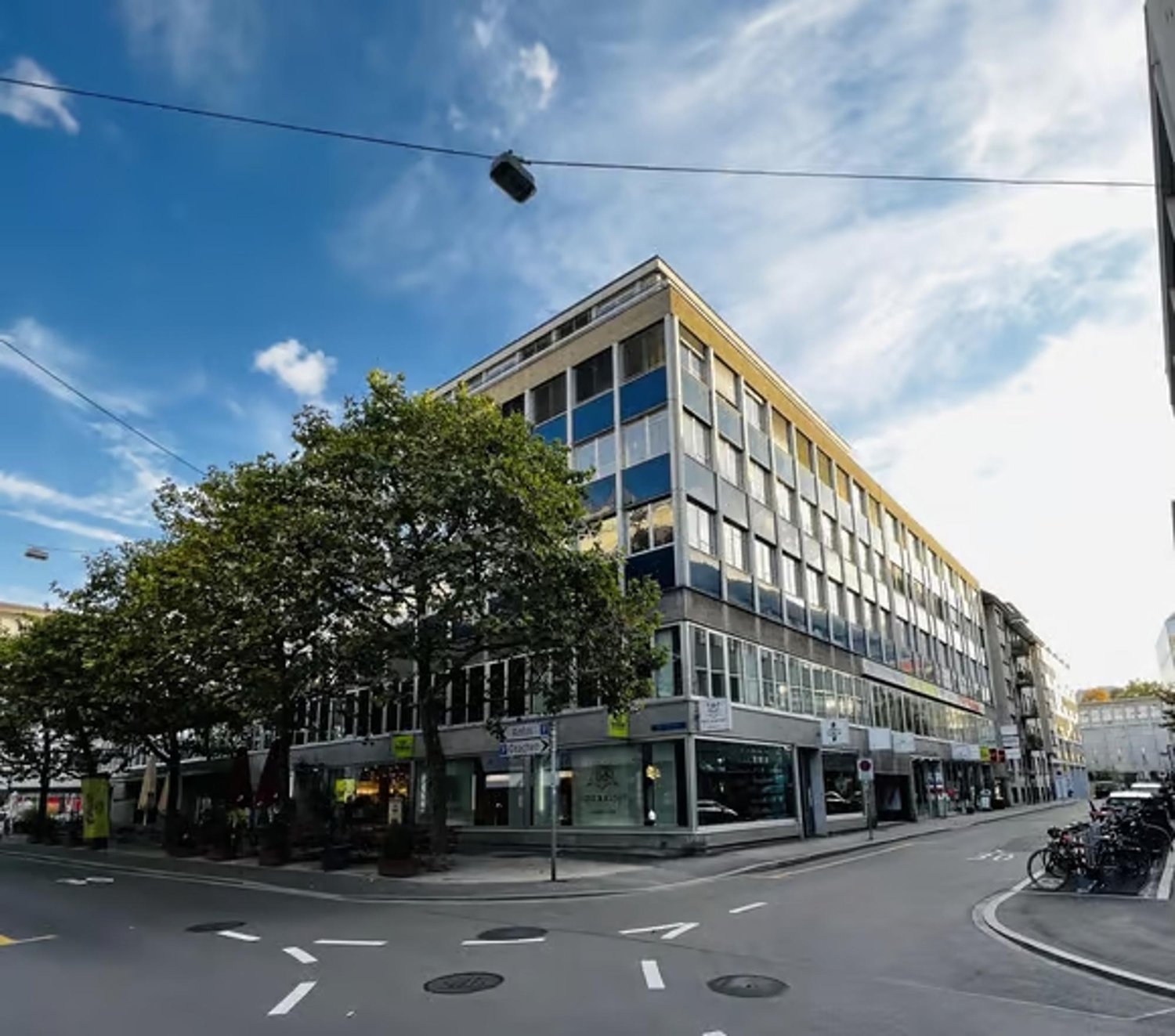 Urban building with glass windows, multiple floors, commercial sign on the front