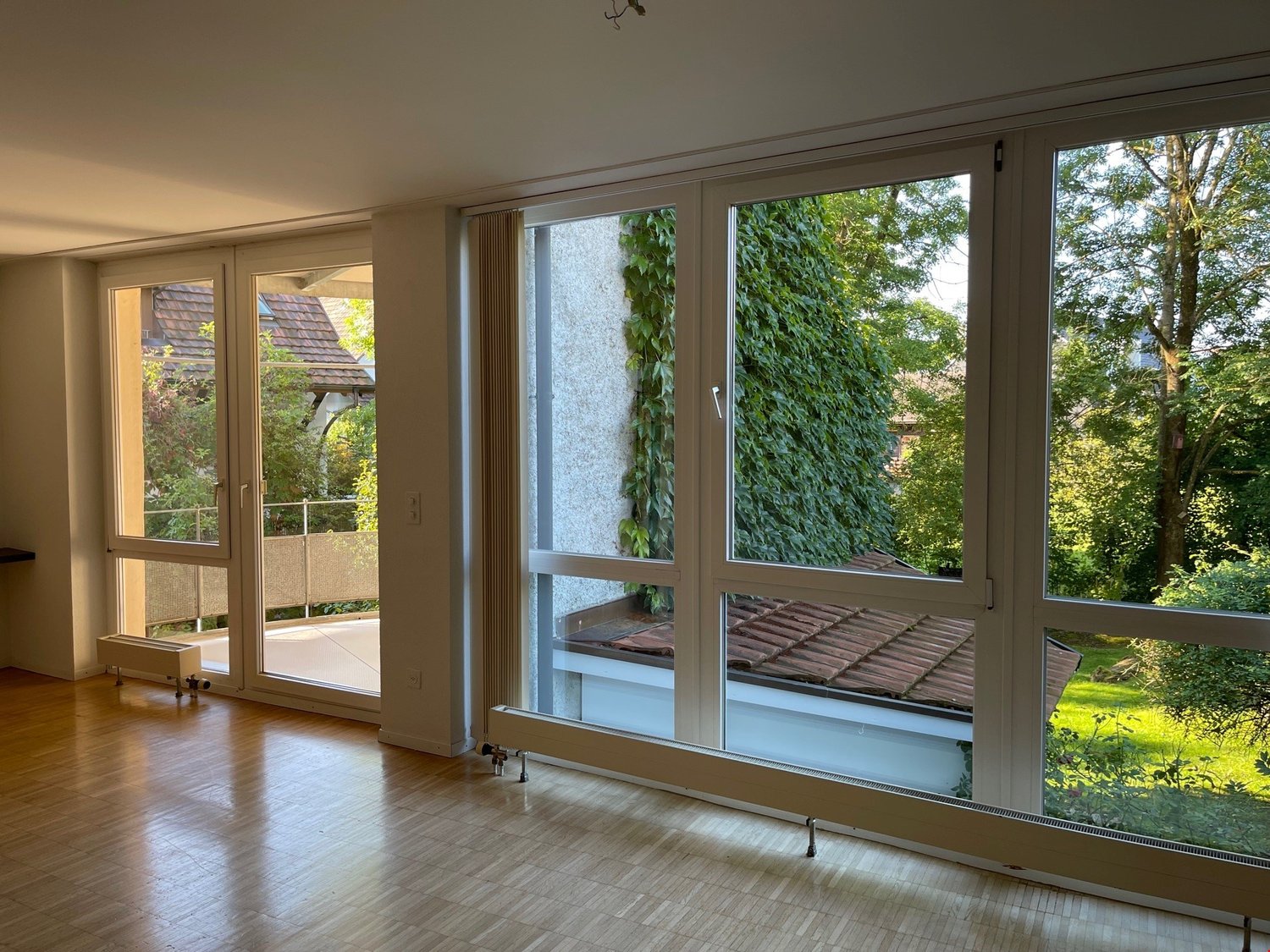 large windows, balcony, hardwood floor, heating radiators, balcony railing