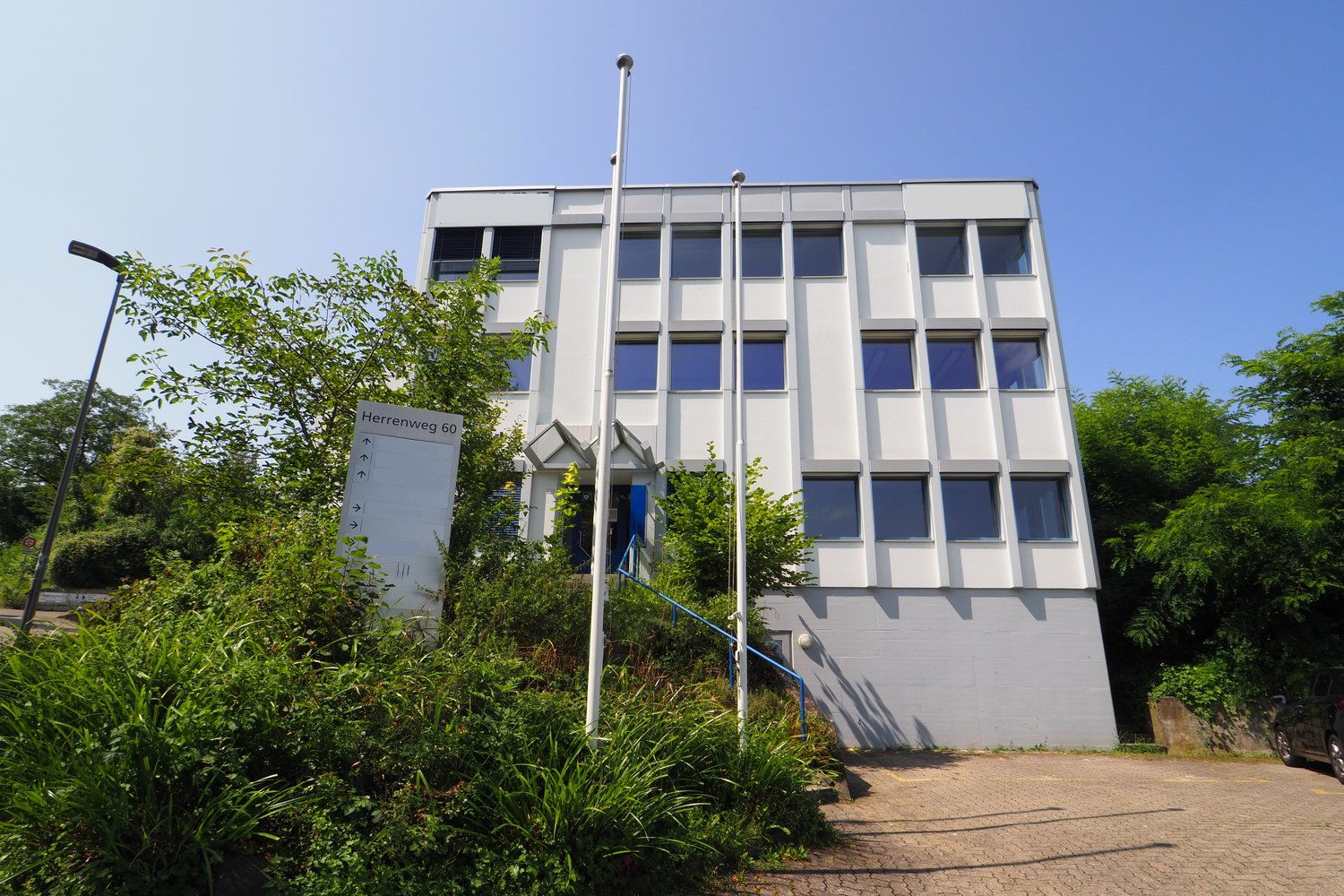 white building, multiple windows, blue door, street light, parking area