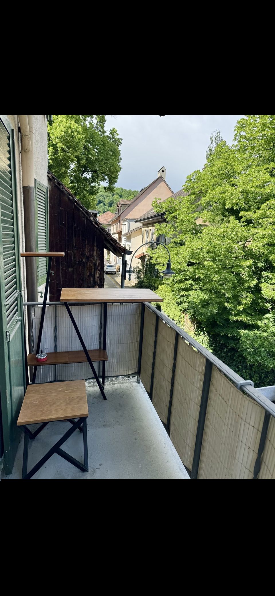 balcony with table, bench, and railings with a tree view