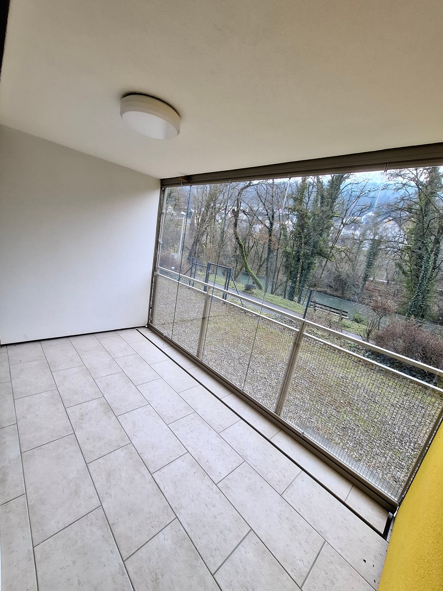 Balcony with tiled floor, large window, empty
