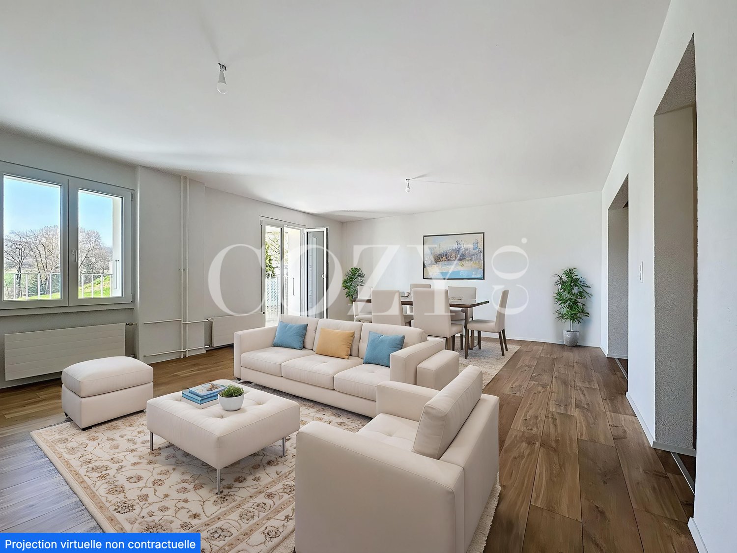 Spacious open-plan living room with large windows, hardwood flooring, beige sofa set, coffee table, and dining area with table and chairs. The room has a bright and airy feel with natural light and potted plants.