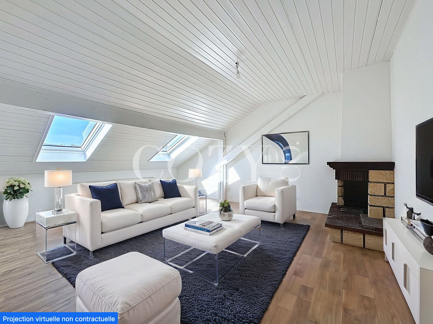Spacious living room with vaulted ceiling, skylights, white sofa and armchair, coffee table, area rug, and a fireplace