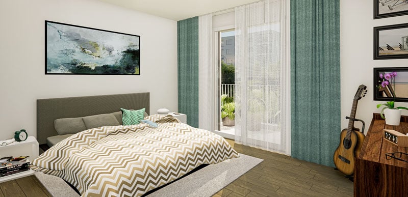 Spacious bedroom with hardwood flooring, large windows with sheer curtains, a green upholstered headboard, a chevron patterned comforter, and a balcony or terrace visible through the window.