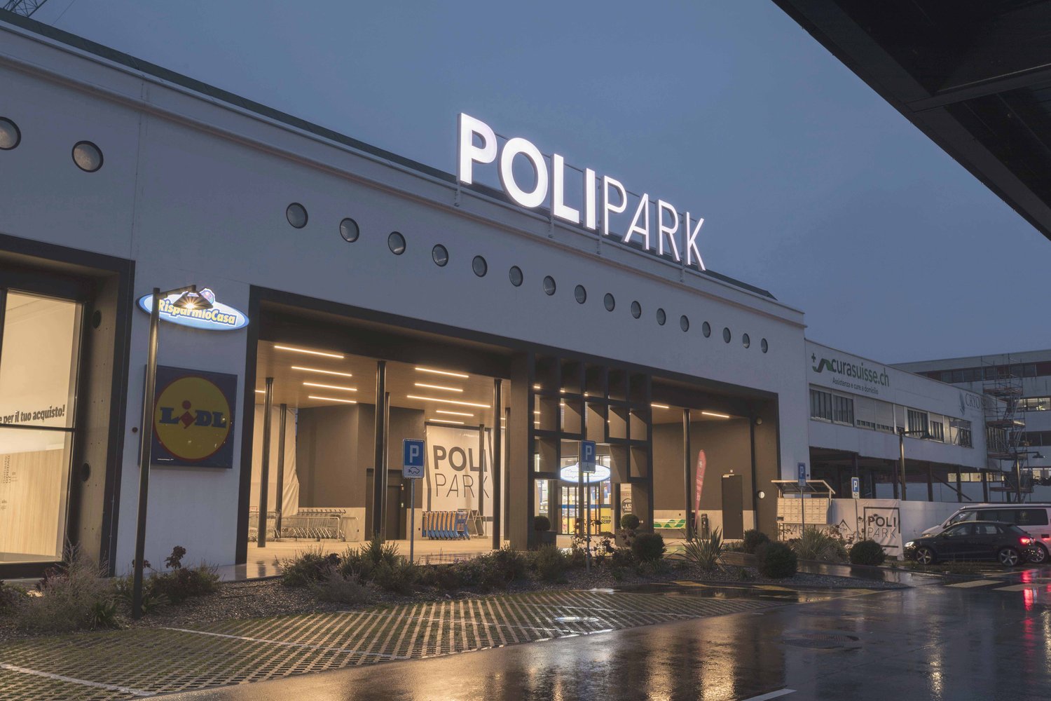 Polipark building with a large sign, multiple circular windows, and a parking area in front