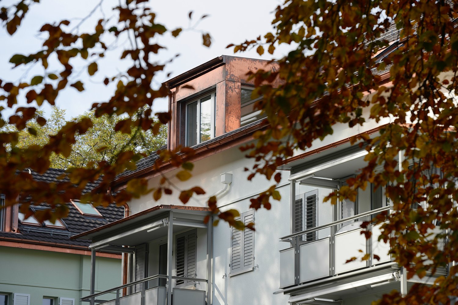 two story building, balcony on second floor, copper roof
