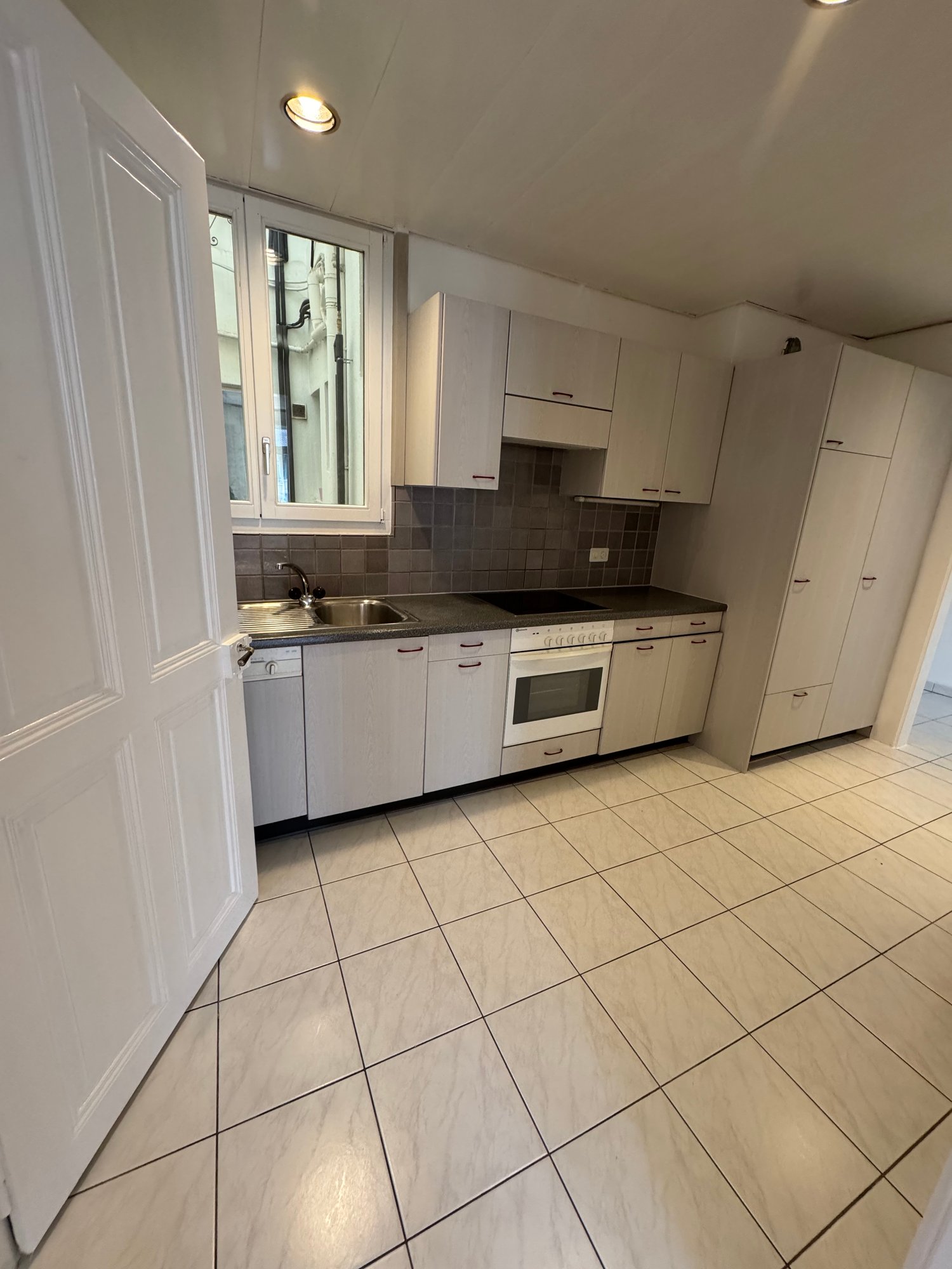 white tiled floor, white cupboards, electric stove, oven, sink, dishwasher