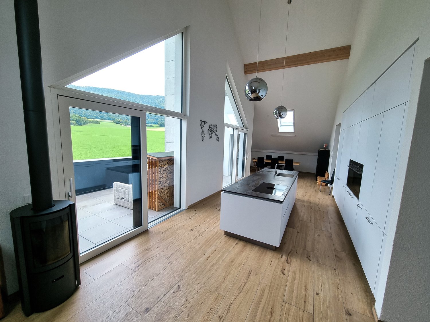 wooden floor, open kitchen, fireplace, sliding door, balcony, dining table, sink, faucet, cabinets, stove