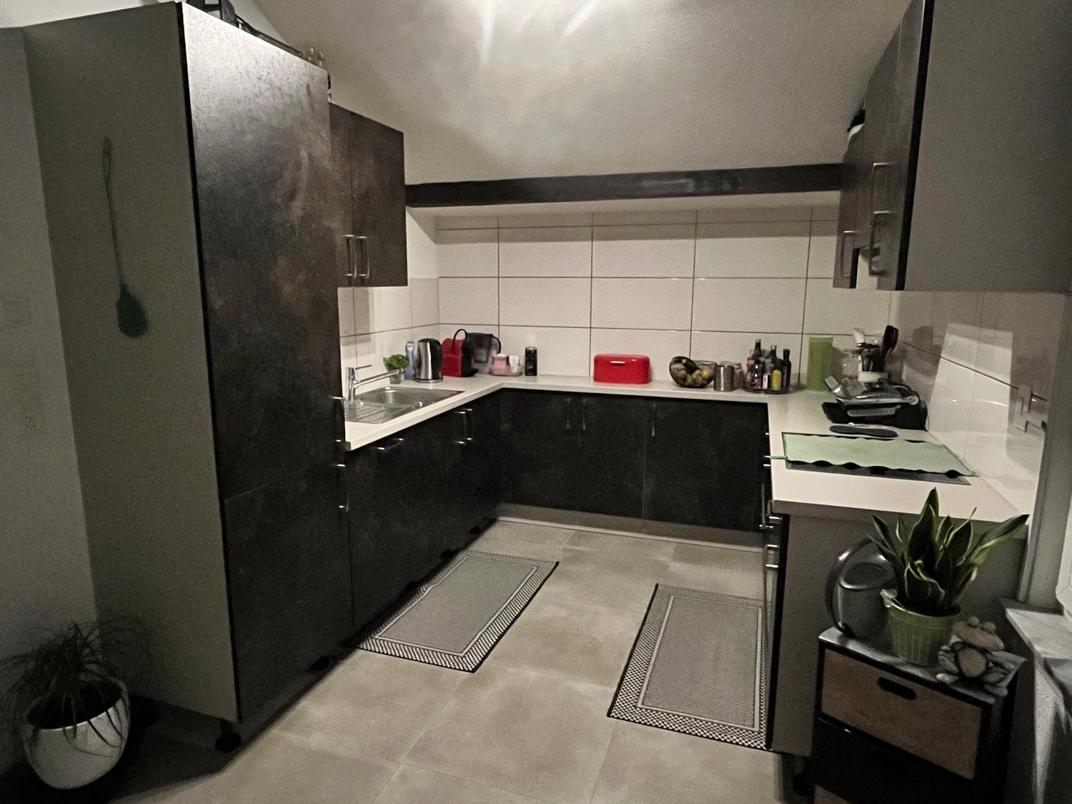tiled floor, dark wood cabinets, countertop with modern sink, coffee machine, toaster, plants