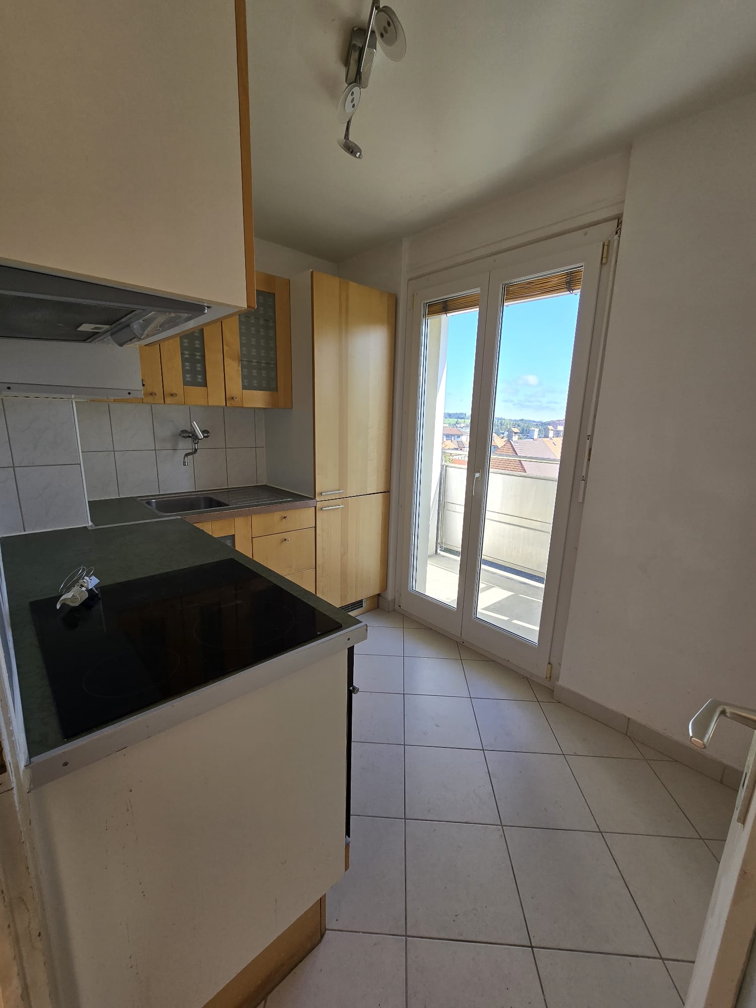 kitchen with appliances, countertop, sink, cabinets, balcony