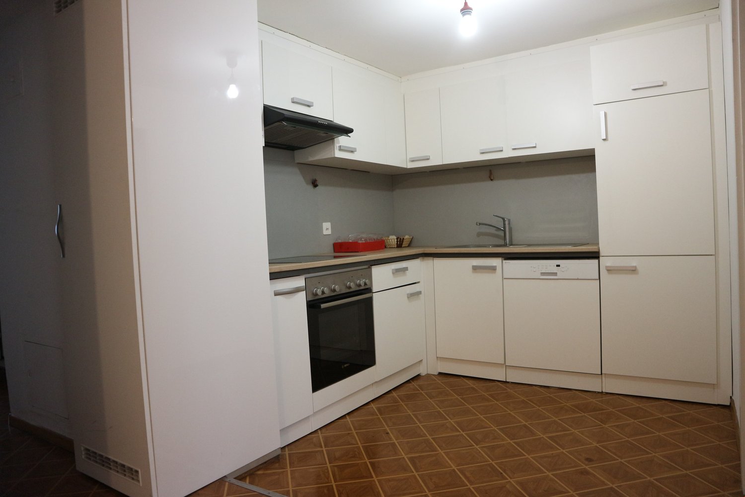 modern kitchen with white cabinetry, dark countertops, oven, dishwasher, sink, faucet