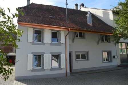 2 story house, white exterior, brown roof, white shutters, brick driveway