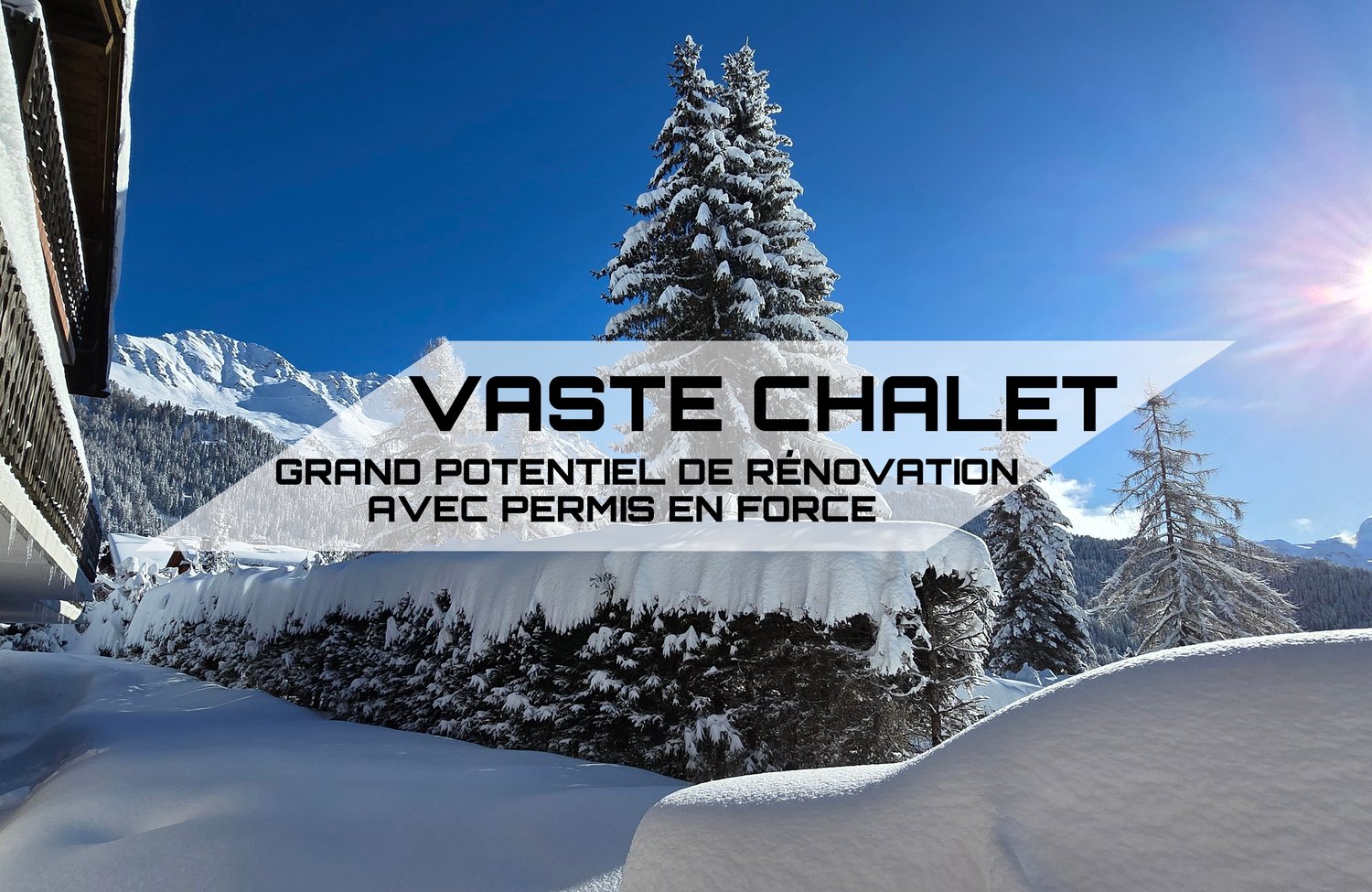 Snowy mountain landscape with a large snow-covered pine tree in the foreground. The image shows a sign for 'Vaste Chalet' indicating a property with 'Grand potentiel de renovation' (great renovation potential) and 'avec permis en force' (with permits in p