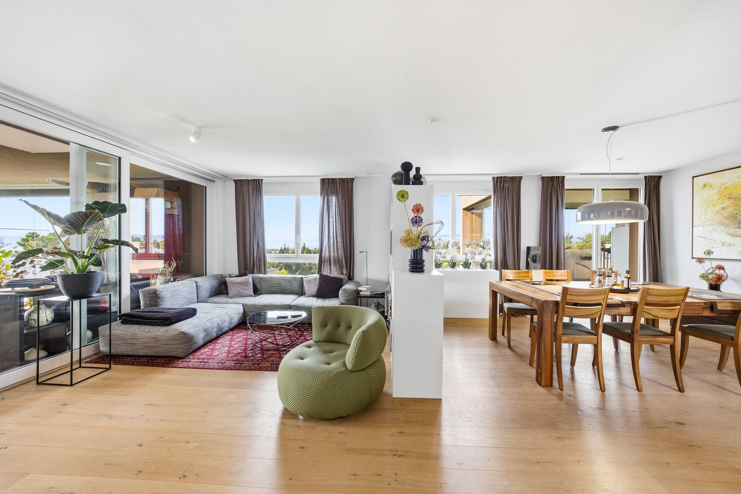 modern interior, large sofa, coffee table, green chair, dining table, windows