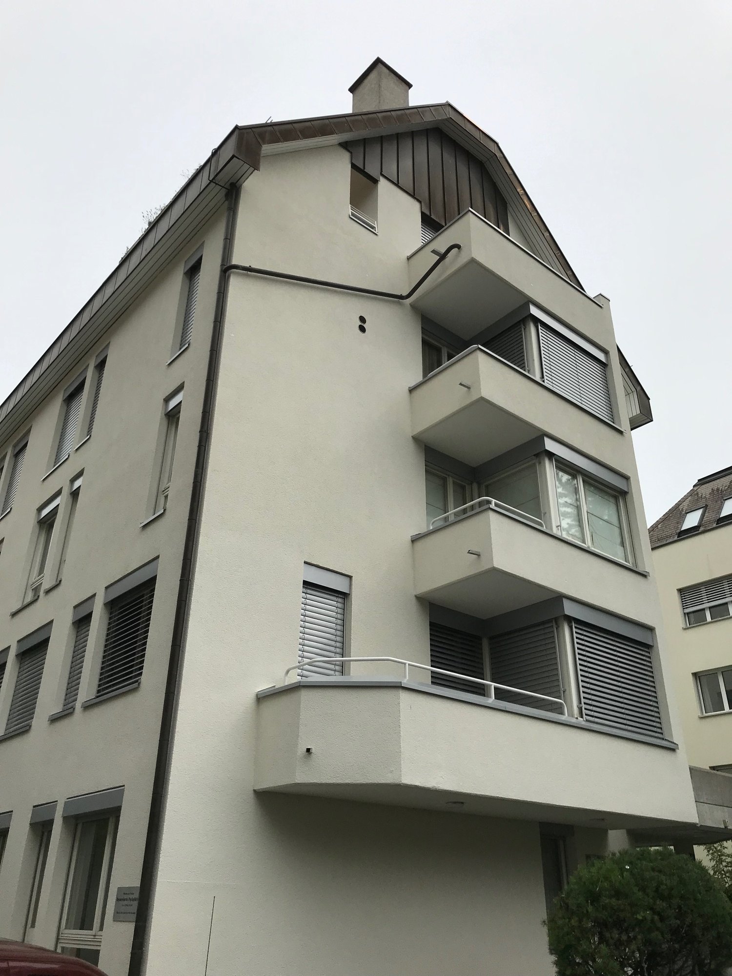 4 story building, white exterior, multiple balconies, windows with shutters