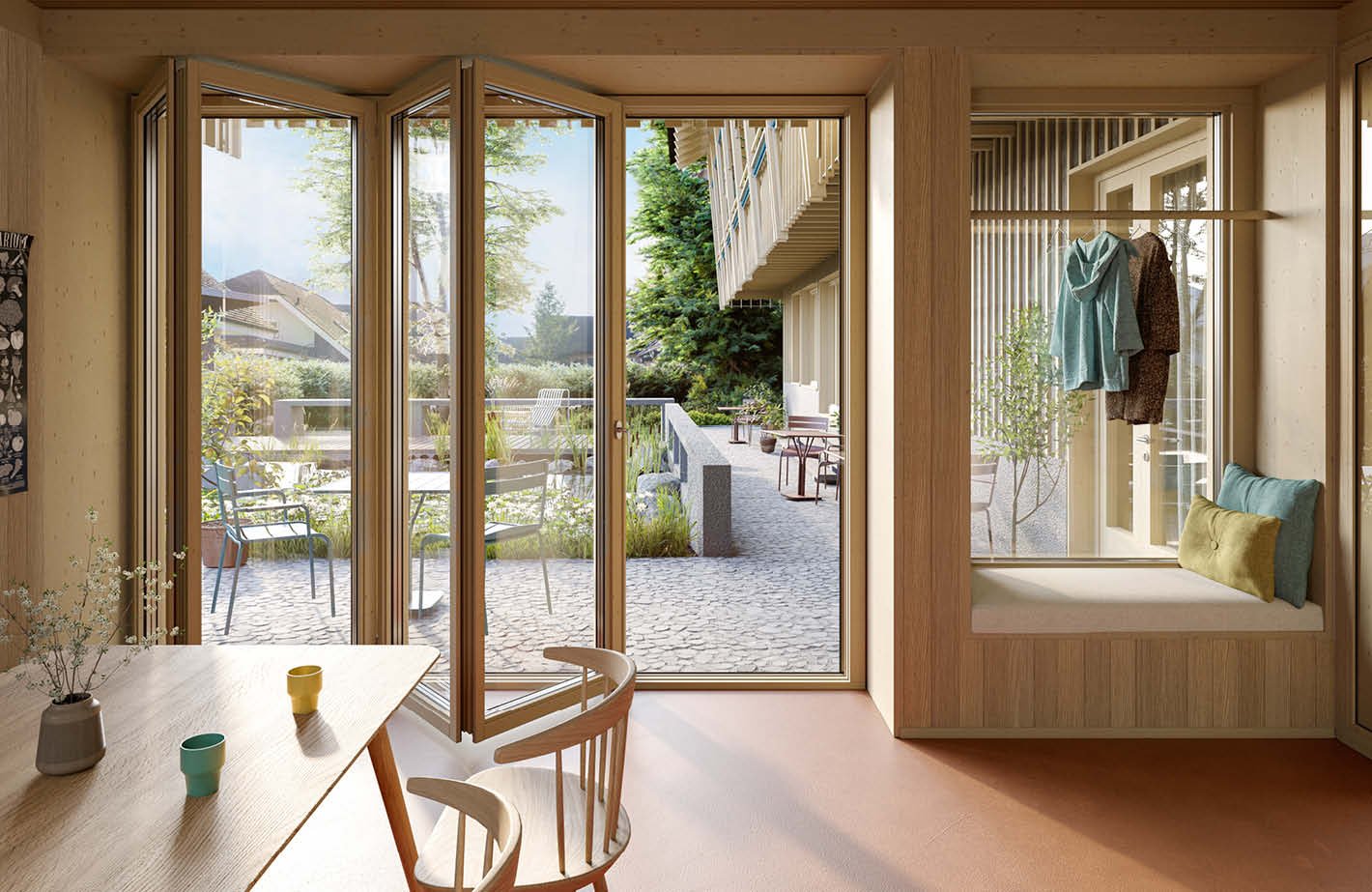 Spacious living room with large windows overlooking a patio and garden area, wooden furniture including a round dining table and chairs, and a built-in window seat with cushions.