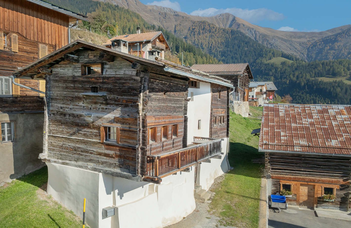 wooden facade, old house, wooden balcony, mountain view, surrounding houses