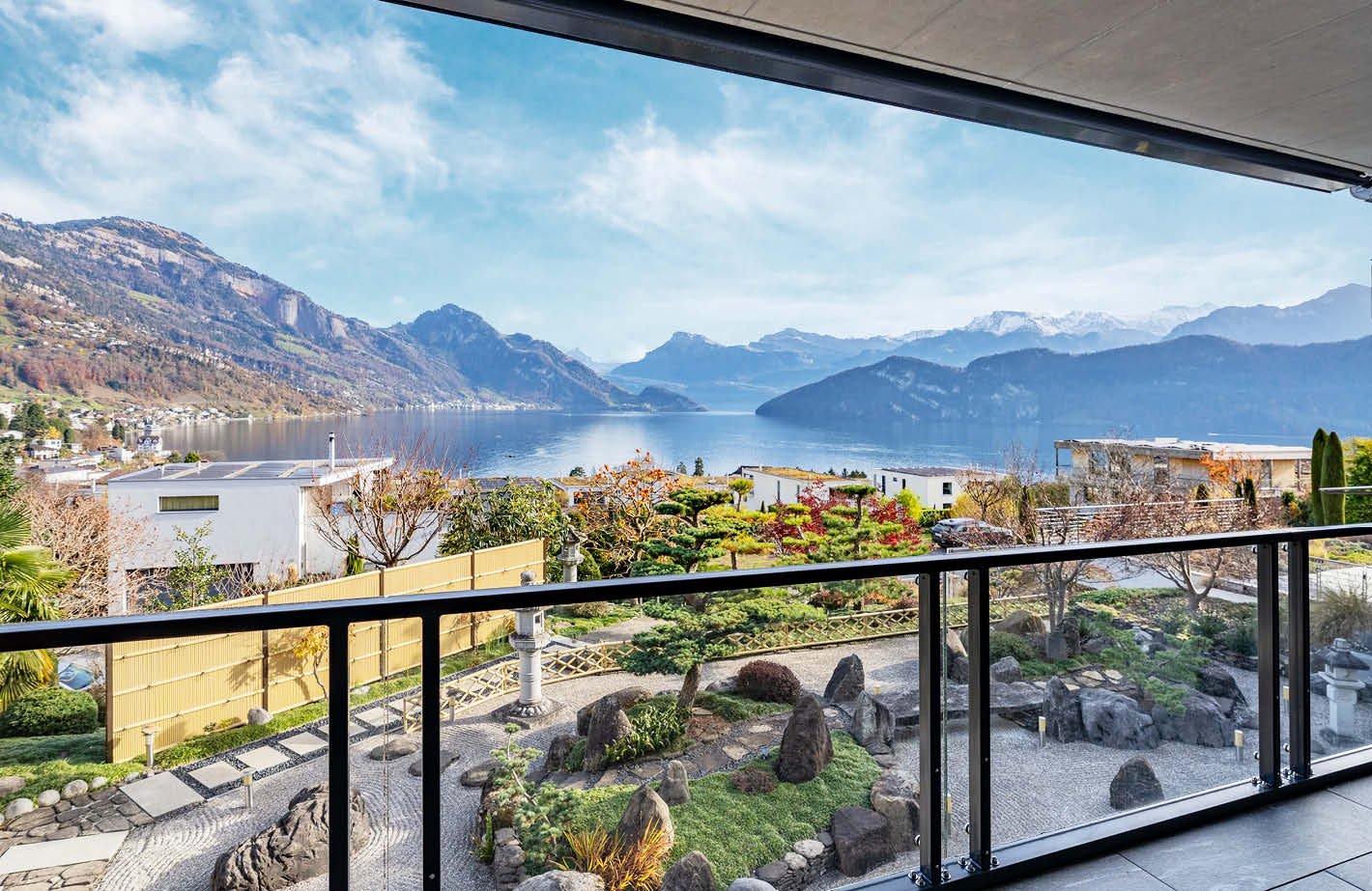 View of mountains, lake, trees and buildings from balcony