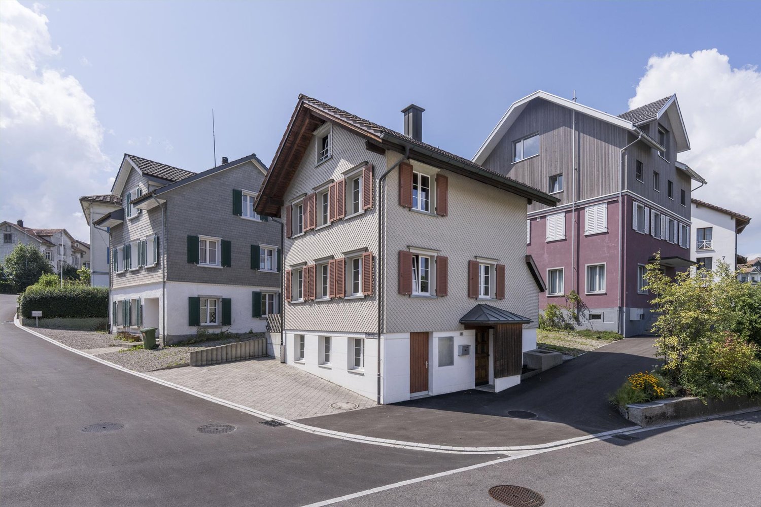 Two story house, white and gray paint, brown shutters, balcony, driveway
