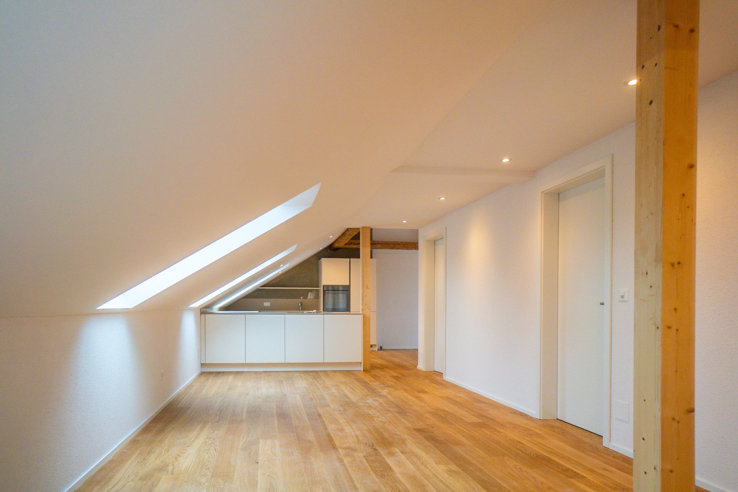 wooden floor, white walls, exposed wooden beam, kitchen, windows