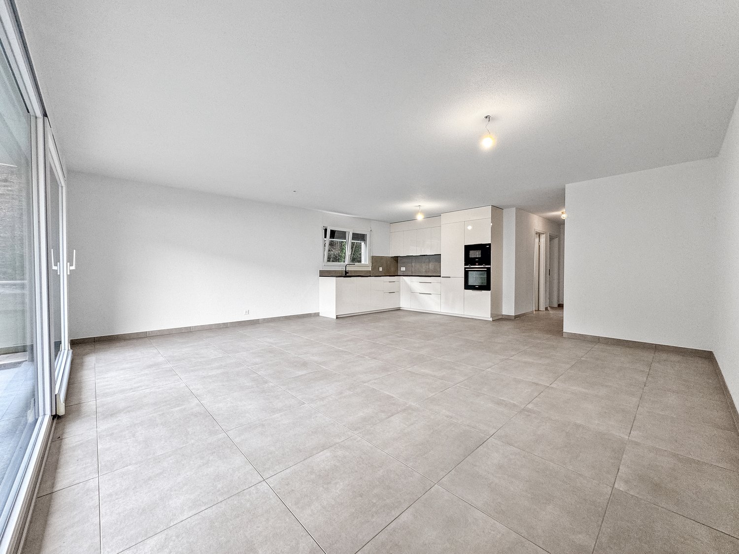 large open room, kitchen, large windows, balcony, tile flooring