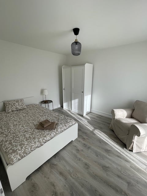 bedroom with bed, nightstand, wardrobe, couch, lamp