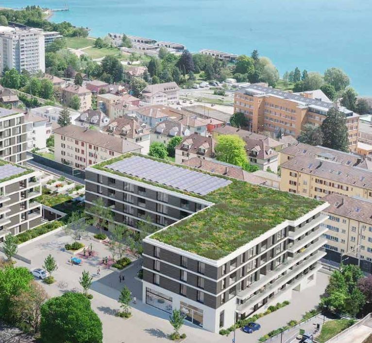 Multi-story building, solar panels on the roof, greenery, water body nearby, parking area, city skyline in the background