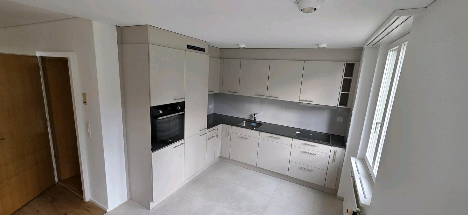 empty kitchen with modern design, modern appliances, white cabinets, wooden flooring