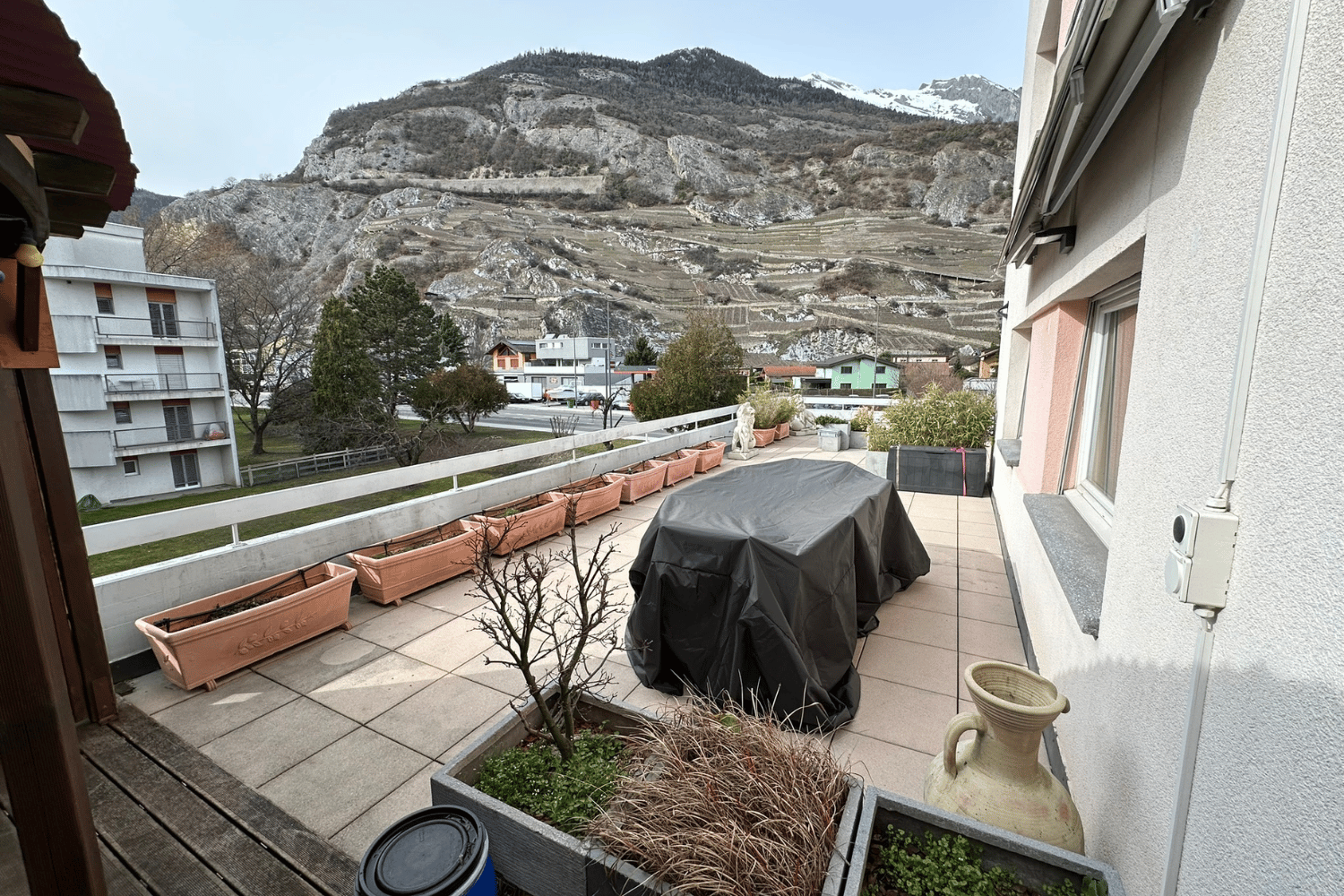 Outdoor space, covered terrace, green landscape, trees, mountains, covered table, wooden deck