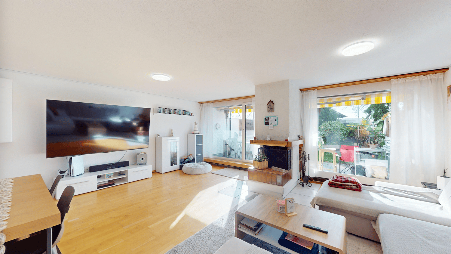 Open plan living and dining room with large balcony, fireplace and sliding doors leading to the balcony