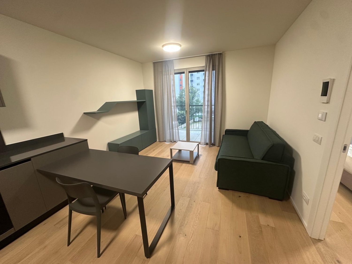 open space with table, chairs, couch, shelves, and balcony with windows