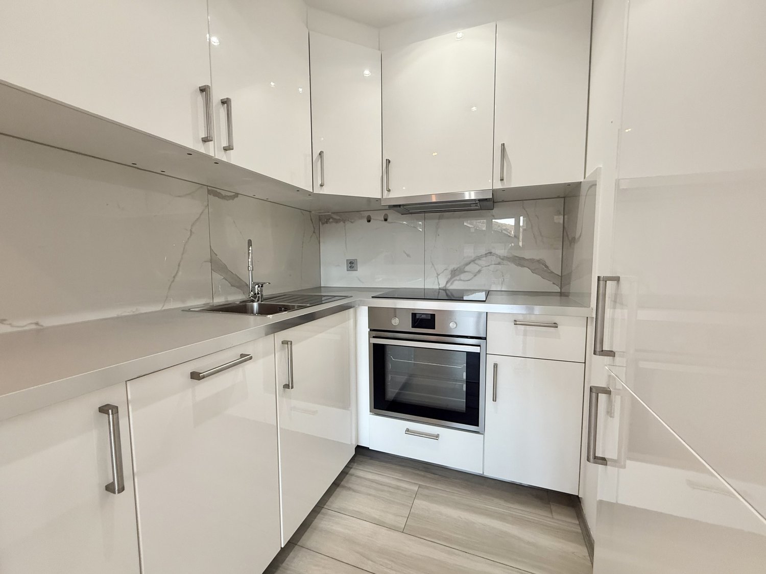 modern white kitchen, stainless steel oven, granite countertops, modern white cabinets, stainless steel sink