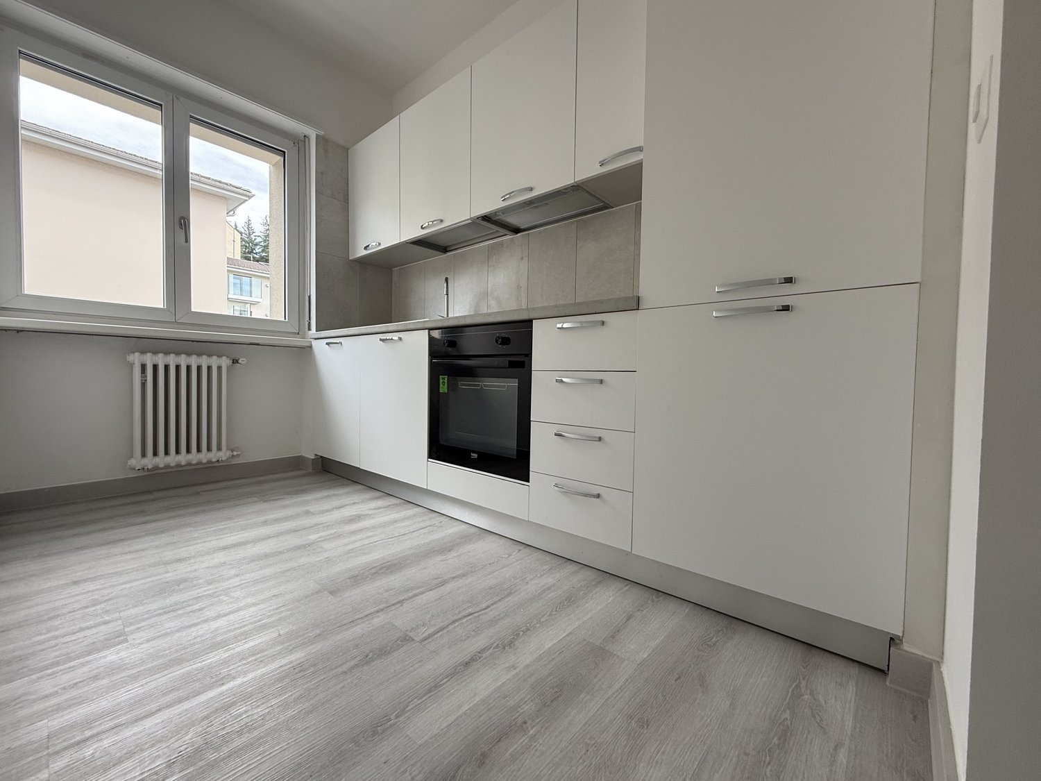empty kitchen with built-in oven and dishwasher, underfloor heating, open floor plan