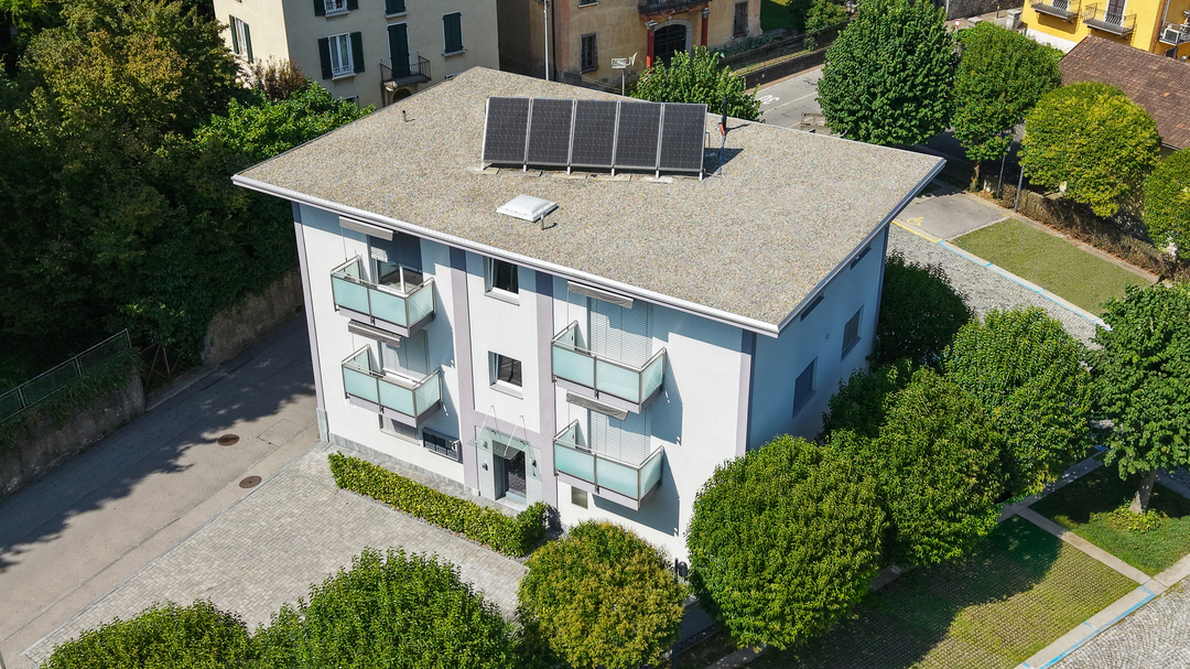 3 story house, white exterior, solar panels on roof, balconies on each floor