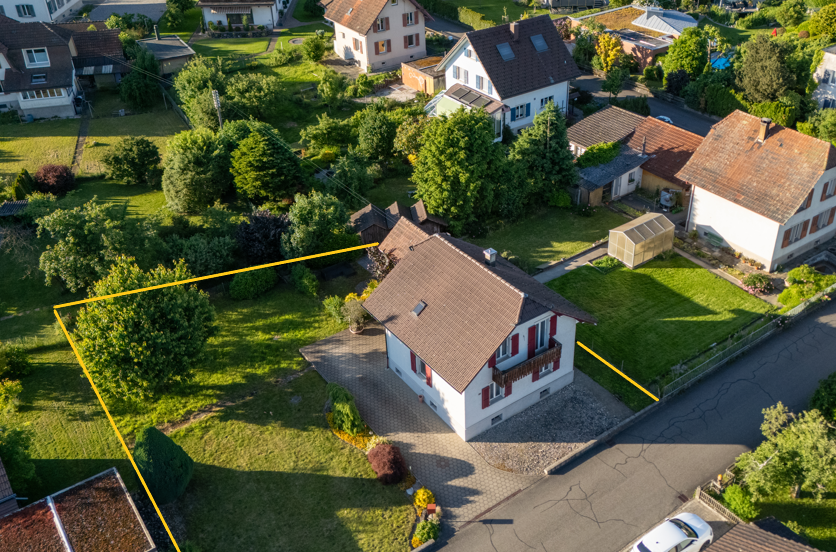 2-story house with brown roof, driveway, small garden, garage