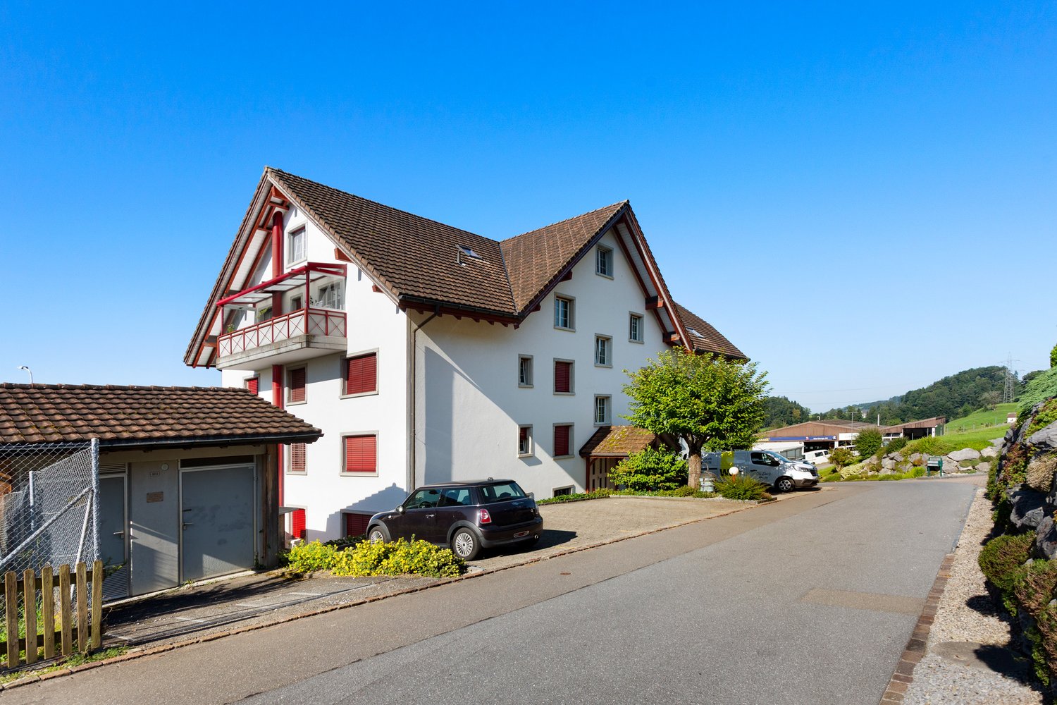 2-story house, white exterior, brown roof, red shutters, garage, black car parked in front
