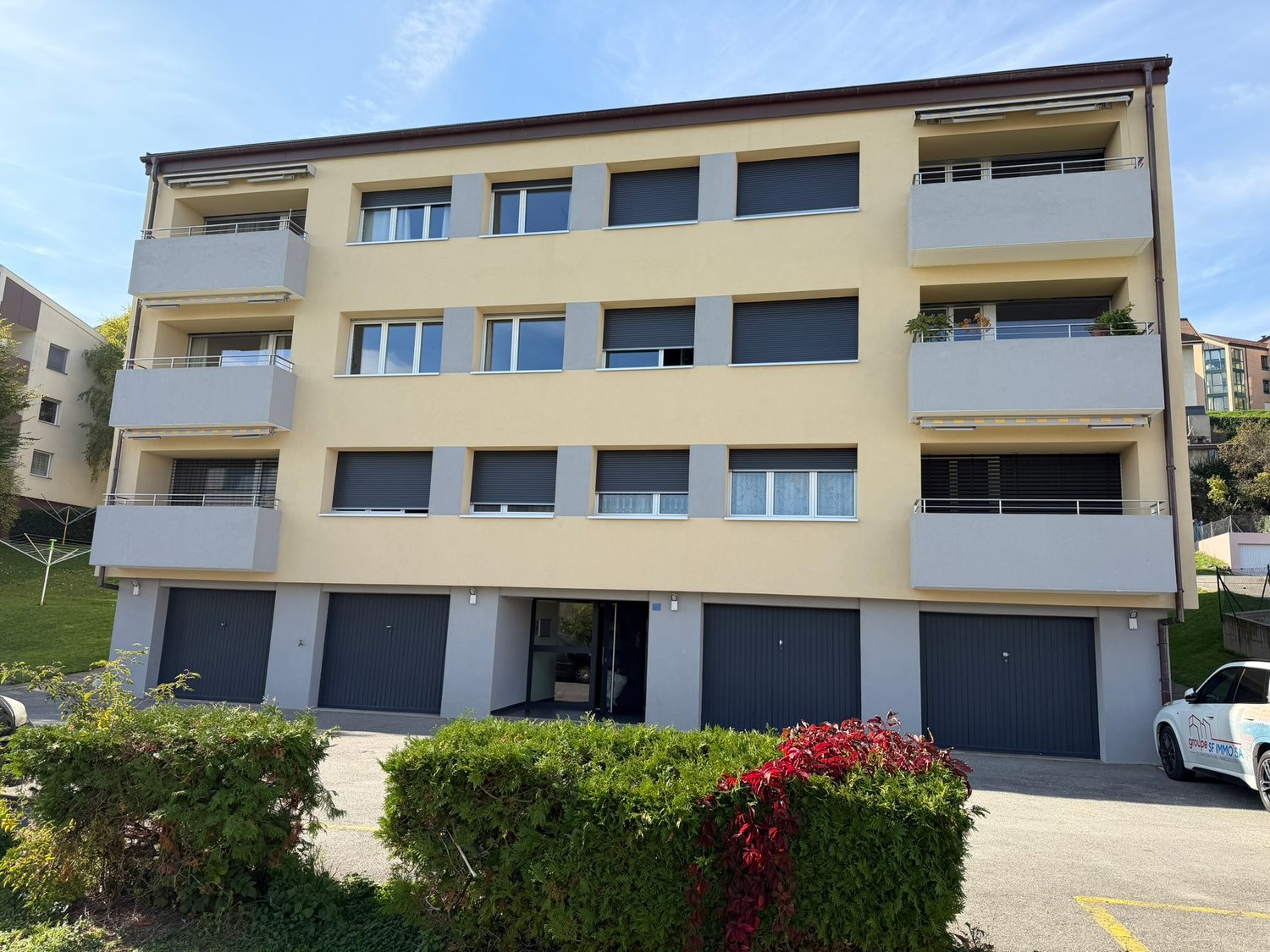 3 story apartment building, beige color, 4 garages, balconies