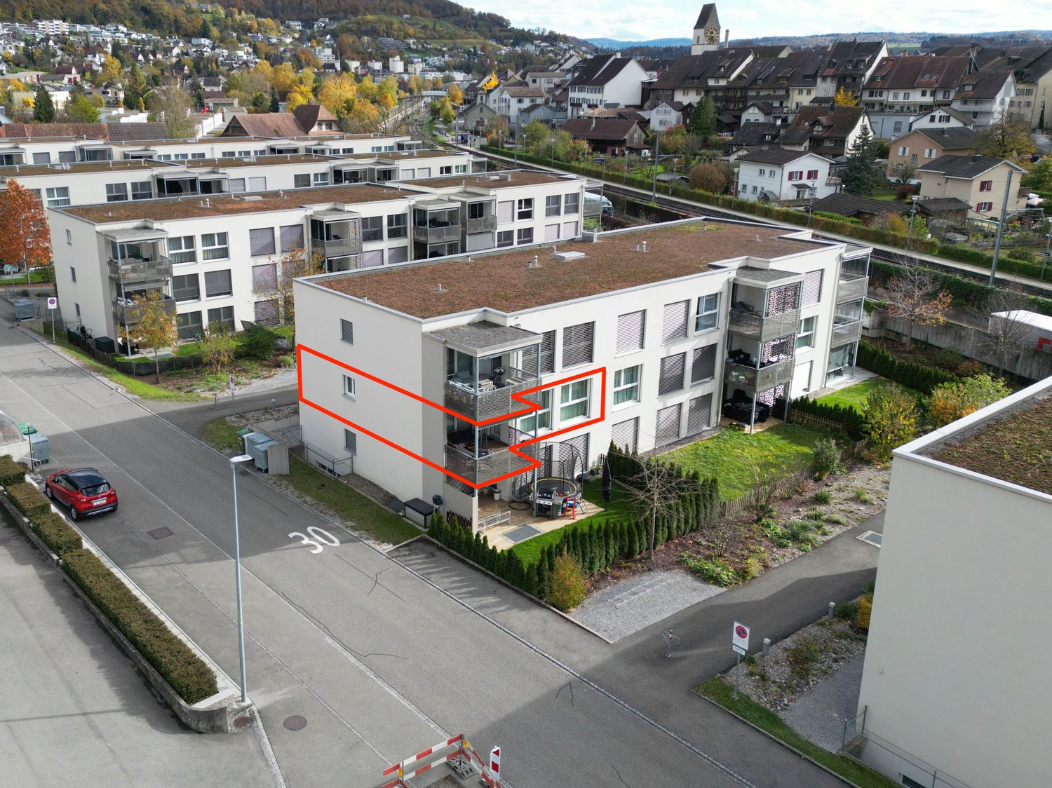white, modern building, multiple floors, terrace in highlighted unit