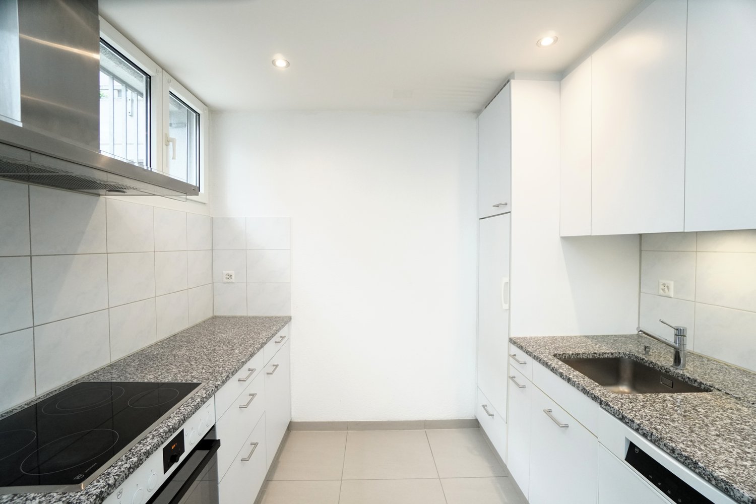 tiled kitchen with granite countertop, modern appliances including dishwasher, induction stove, refrigerator, kitchen cabinets, window