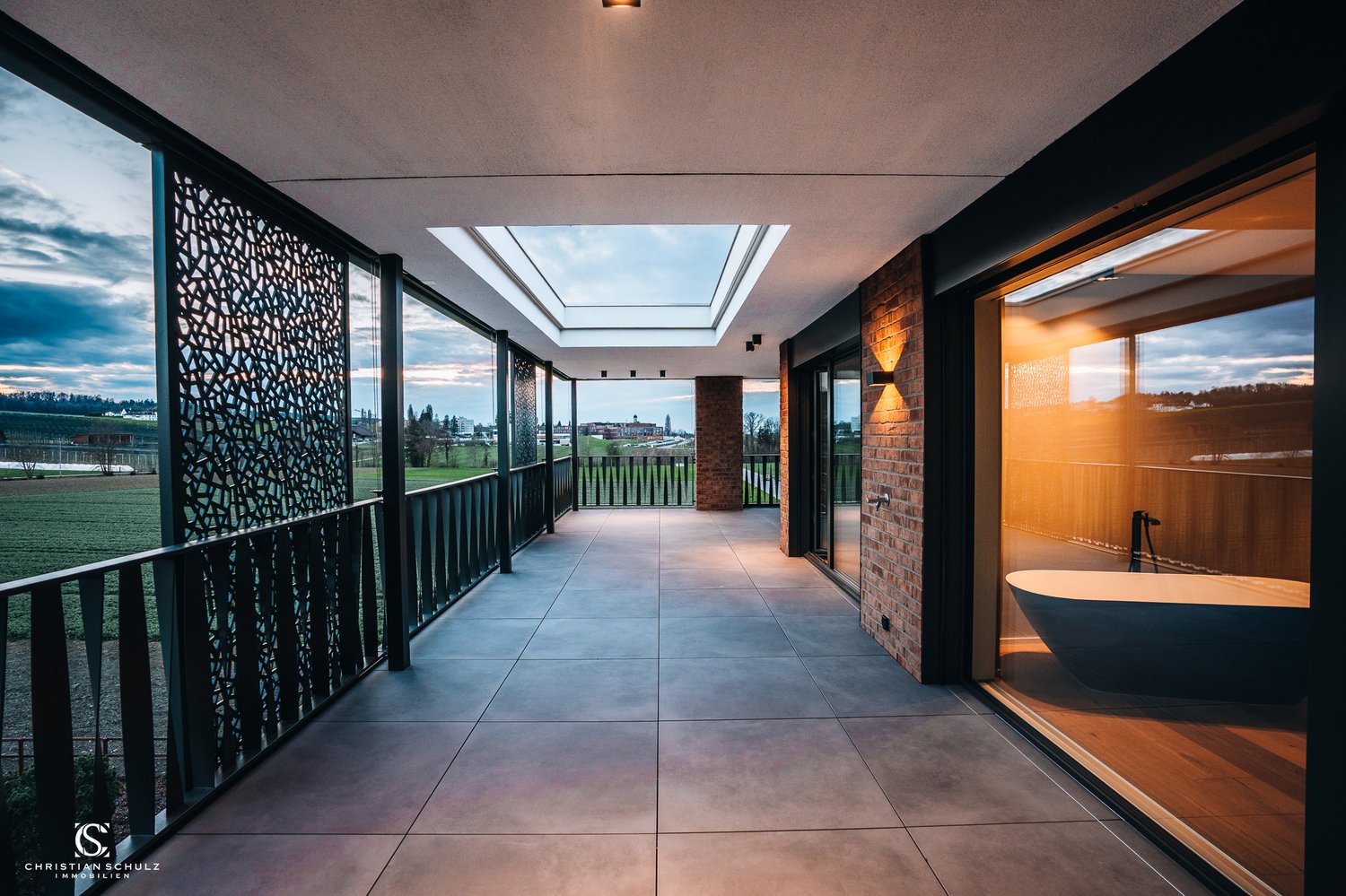 Terrace balcony, glass windows, brick pillars, skylit ceiling, metal railings, bathtub view