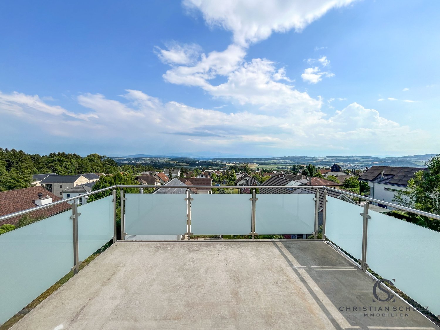 Terrace with glass railings and panoramic view of the countryside